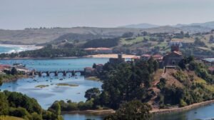 Vista aérea escénica del encantador paisaje de San Vicente de la Barquera con puente y río.