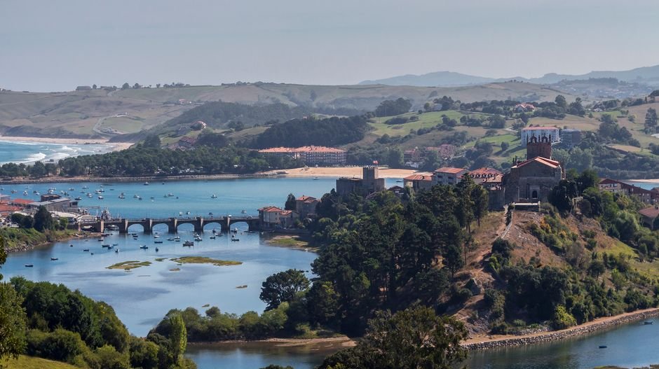 Vista aérea escénica del encantador paisaje de San Vicente de la Barquera con puente y río.