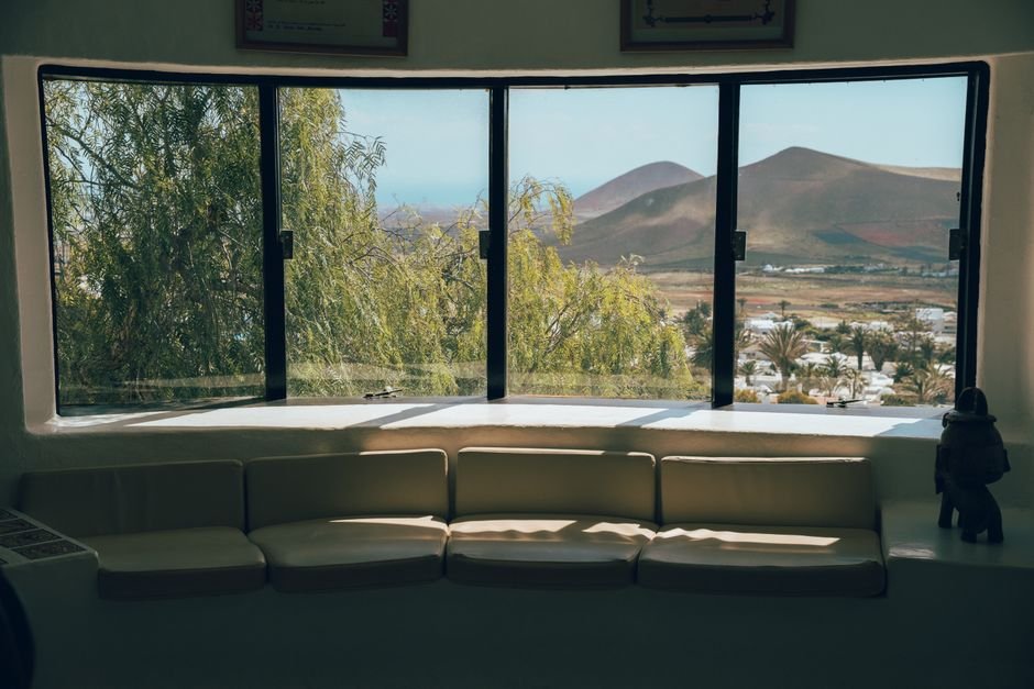 Acogedora vista interior que muestra el hermoso paisaje de Lanzarote a través de grandes ventanas.