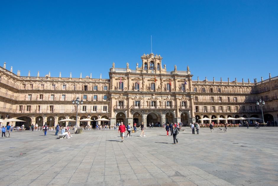 Una escena bulliciosa en la Plaza Mayor de Salamanca, España, con personas disfrutando de la vibrante atmósfera.
